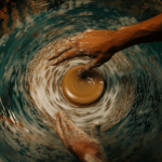 a person working with clay on a wheel